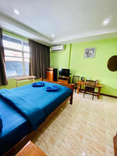 卡塔海滩BT hotel Kata Beach的一间带蓝色床的卧室和一间客厅
