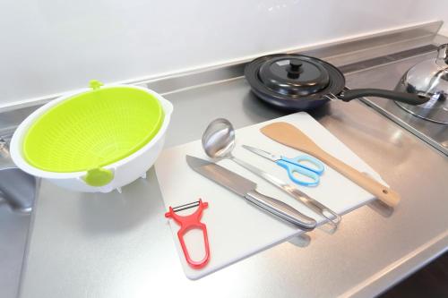 小樽Sungarden - Vacation STAY 95967的厨房柜台设有绿色碗和剪刀