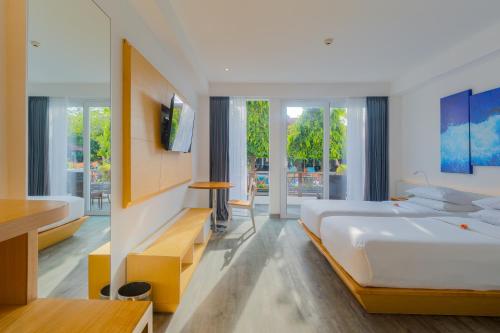 库塔Kuta Beach Club Hotel的一间带大床和电视的卧室