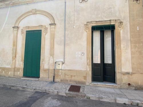 San Pietro in LamaCasa del Nonno Toto的建筑物一侧的两扇绿门