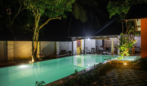 达瓦拉维乌达瓦拉瓦大象休憩酒店的夜间游泳池,灯光照亮