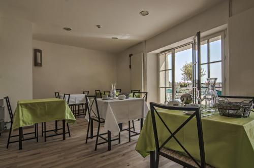 Saint-Michel-lʼObservatoire加利利酒店的一间带桌椅的用餐室和窗户。