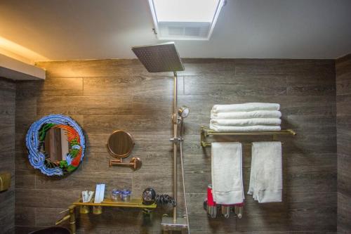 腾冲腾冲和顺古镇崇尚坊客栈的一间带毛巾和镜子的淋浴的浴室