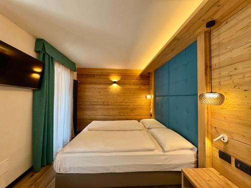 卡纳泽伊Dolomiti Luxury Mountain View的木制客房内的一间卧室,配有一张床