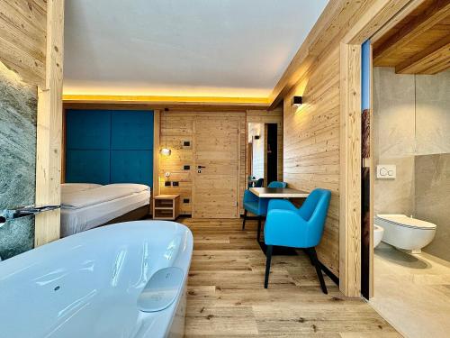 卡纳泽伊Dolomiti Luxury Mountain View的带浴缸的浴室和卧室
