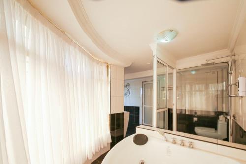 内罗毕Eldon Suites & Apartments的带浴缸的浴室和大窗户