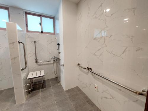 安平区安平商旅Choona Hotel Anping的浴室设有白色大理石墙壁和步入式淋浴间。