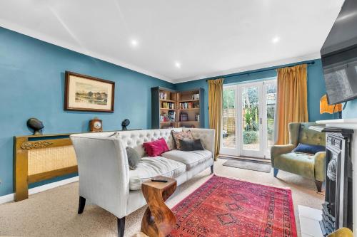 红山Reigate Gem的客厅拥有蓝色的墙壁和白色的沙发