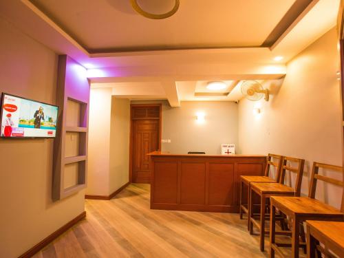 NgateuMedan Hotel的一间带木桌的餐厅和一间拥有紫色灯光的酒吧