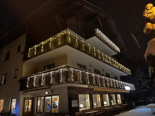 奥布施泰希Pension Alpina的一座晚上用圣诞灯装饰的建筑