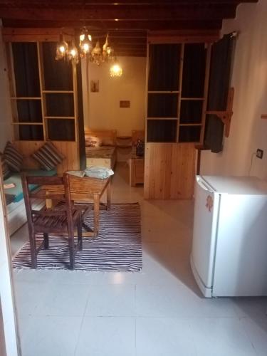 达哈布بيت مازن的客厅配有桌子和冰箱