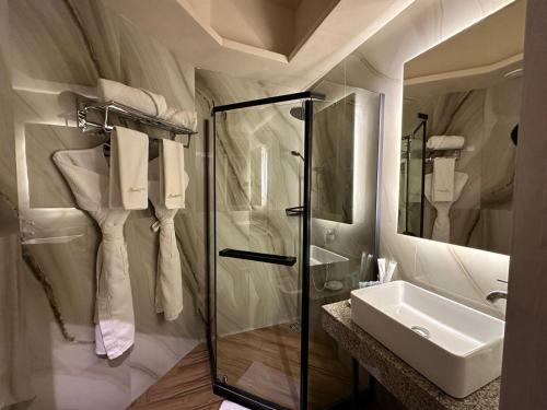 塔拉兹Barhat Resort的一间带玻璃淋浴和水槽的浴室