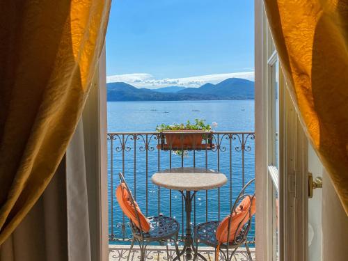 卡尼洛瑞维拉Hotel Cannero的阳台配有桌椅,享有水景。