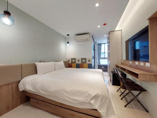 安平区安平商旅Choona Hotel Anping的一间卧室配有一张大床和一张书桌