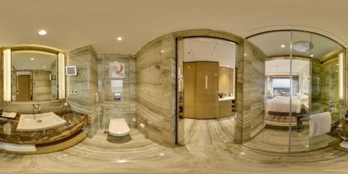 勒克瑙勒克瑙万丽酒店的浴室设有大房间,配有一张床和镜子