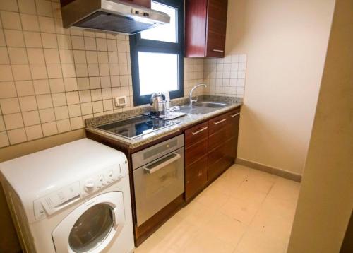 加利布港Port Ghalib Marina Residence Suites的小厨房配有洗衣机和水槽