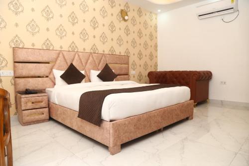 大诺伊达MK Regency的一间卧室配有一张大床和木制床头板