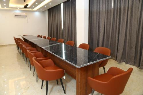 大诺伊达MK Regency的一间会议室,配有长桌子和橙色椅子