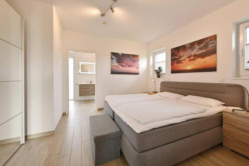 特伦特Villa Strandgut的一间卧室配有一张带白色床单的大床