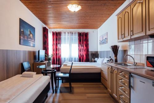 汉堡Hotel Hanseat Hamburg的带两张床的房间和带桌子的厨房