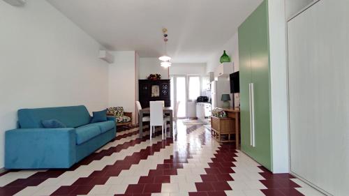 科尔萨诺L' Appoggio - Monolocale Eco-sostenibile A Due Passi Dal Centro Storico的一间带蓝色沙发的客厅和一间厨房