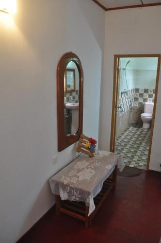 南塔拉拉Sea Breeze Inn Talalla的一间带镜子、桌子和卫生间的浴室