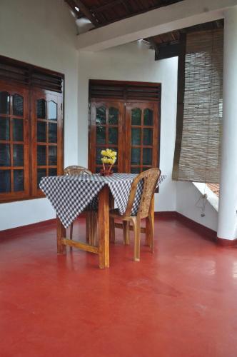 南塔拉拉Sea Breeze Inn Talalla的餐桌,椅子和花瓶