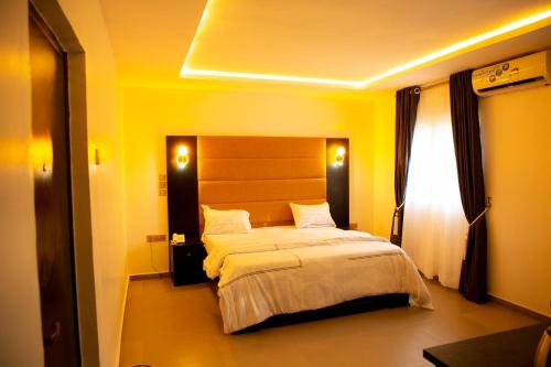 乌约Cogent Apartments Single Rooms的黄色客房内的一间卧室配有一张大床