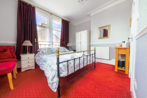 凯西克Goodwin House的一间卧室配有一张床,铺有红色地毯