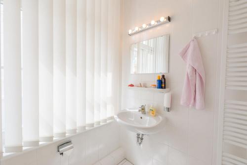 奥斯赛拜-屈隆斯博恩Appartementhaus Villa Norden的白色的浴室设有水槽和镜子