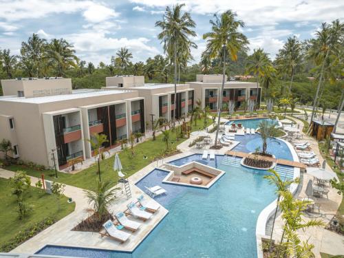 雅帕拉廷加Japaratinga Lounge Resort - All Inclusive的享有带游泳池的度假村的空中景致