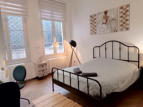 鲁昂Appartement centre ville的一间卧室配有一张床、一盏灯和两个窗户