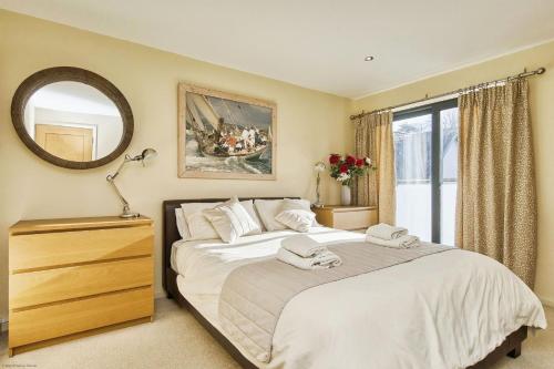 考斯Seafront Quay West Apartments的一间卧室配有一张大床和镜子