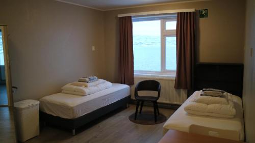 Borðeyri塔安加胡斯旅馆的客房设有两张床、一个窗户和椅子。