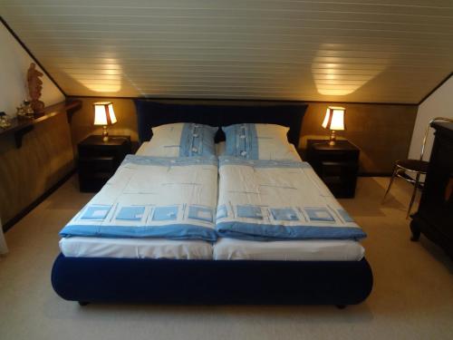 贝尔恩卡斯特尔-库斯Gästehaus am Ahornweg的一间卧室配有两张带蓝白色枕头的床