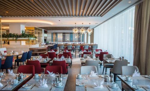 杜布罗夫尼克Rixos Premium Dubrovnik的一间带桌椅的餐厅和一间酒吧