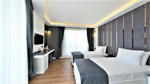 安塔利亚Mai İnci Otel的酒店客房设有两张床和电视。
