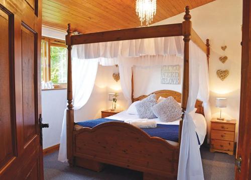 彻克Brookside Leisure Park的一间卧室配有一张天蓬床、蓝色床单和枕头