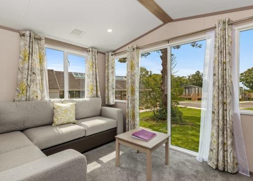 ReynaltonCroft Country Park的带沙发和大窗户的客厅