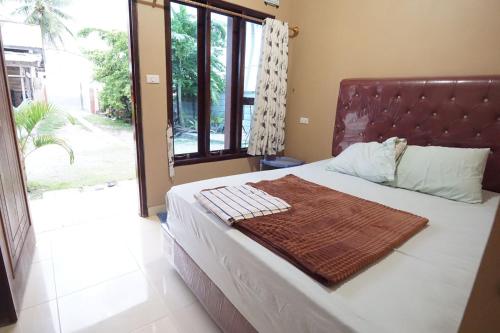 比哈尔Sapu Nyapah Losmen Syariah Tanjung Setia的一间卧室配有一张床铺,床上有毯子