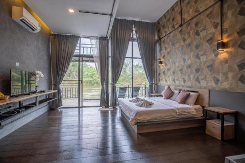 塞友Kwai Tara Riverside Villas的一间卧室设有一张床和一个大窗户