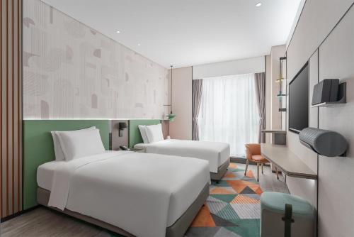 中山EVEN Hotel 中山中心逸衡酒店的一间酒店客房,设有两张床和电视