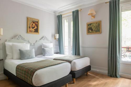 巴黎德拉波特多雷酒店的酒店客房设有两张床和窗户。