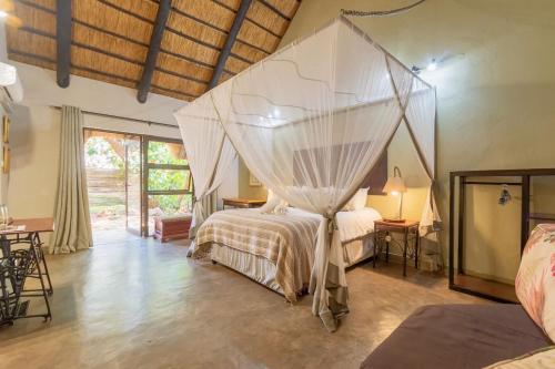 维多利亚瀑布Nguni Lodge的一间卧室配有一张带蚊帐的床