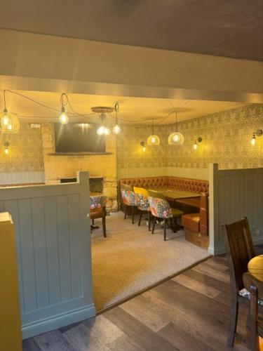 谢伯恩Britannia inn的客厅配有桌椅和电视。