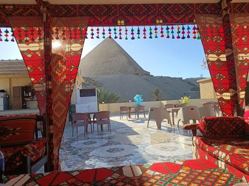开罗Crystal pyramid inn的配有桌椅的房间享有金字塔的景色
