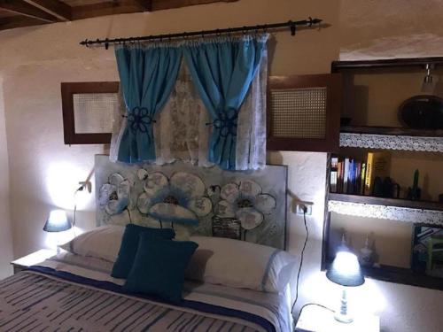 埃尔米瓜Casa rural con Wifi y estupenda vista a la montaña en Hermigua的一间卧室配有一张带蓝色窗帘的大床