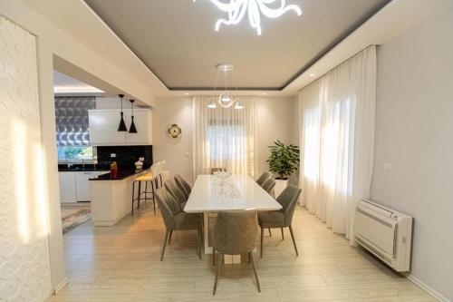 伏罗拉VILA LLANO的用餐室以及带白色桌椅的厨房