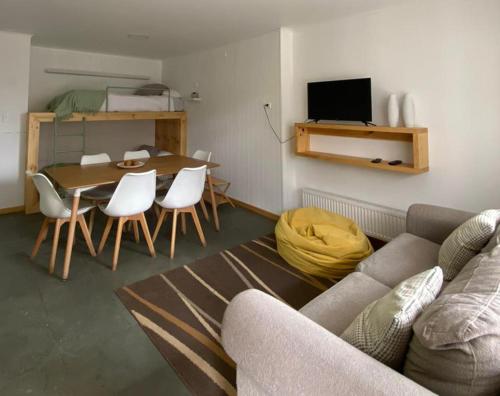 纳塔列斯港Natagonia Apartments的客厅配有沙发和桌椅