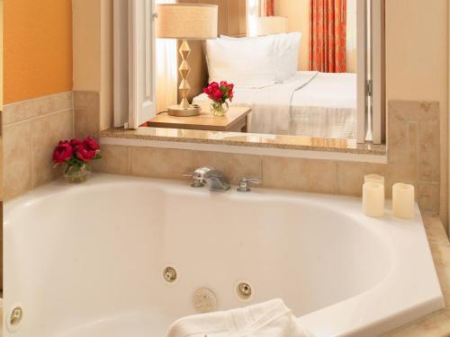 奥兰多Floridays Orlando Two & Three Bed Rooms Condo Resort的带浴缸的浴室和卧室